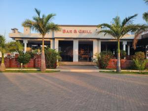 a restaurant with palm trees in front of a building at City Link Complex Ressort in Mwanza +9 photos