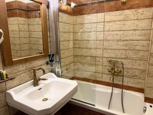 a bathroom with a sink and a bath tub at Thermes Pozar Resort in Kato Loutraki