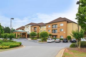a building with cars parked in a parking lot at Courtyard Atlanta Suwanee in Suwanee