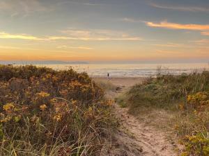 a person walking on the beach at sunset at Båstad Ateljehus in Båstad