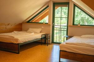 two beds in a room with two windows at HolzHaus AusZeit am Küppel & Bright Collection in Gersfeld
