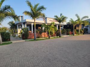 a building with palm trees in front of a street at City Link Complex Ressort in Mwanza
