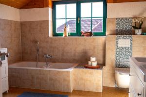 a bathroom with a tub and a toilet at HolzHaus AusZeit am Küppel & Bright Collection in Gersfeld +127 photos