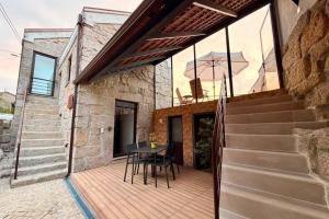 a patio with a table and chairs on a wooden deck at Casa do Largo do Cruzeiro in Vouzela
