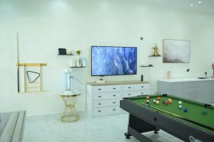 a living room with a pool table and a flat screen tv at Al Miqyal Resort - استراحة المقيال - الساد in Al Ain