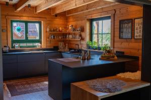 a kitchen with a large island in a wooden kitchen at HolzHaus AusZeit am Küppel & Bright Collection in Gersfeld