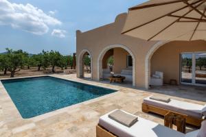 an image of a swimming pool with an umbrella at Oinopia Country Villas in Egina