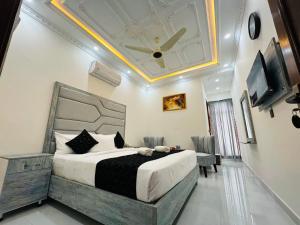 a bedroom with a large bed with a ceiling at Hotel Haven Lahore in Lahore