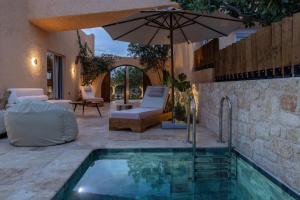 a swimming pool with an umbrella and a patio at Oinopia Country Villas in Egina