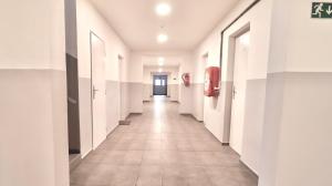 a hallway of a building with white walls and tile floors at Ubytování U Hráze in Liberec