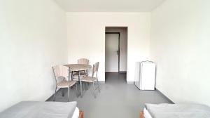 a room with a table and chairs and a refrigerator at Ubytování U Hráze in Liberec