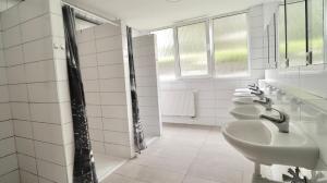a bathroom with a row of sinks and mirrors at Ubytování U Hráze in Liberec