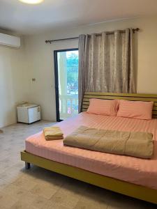 a bedroom with a large bed with a large window at Sky&Sea Guesthouse Cha am TK in Cha Am