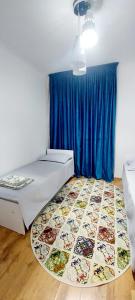 a room with a bed and a blue curtain at Яншина 6 in Qyzylorda