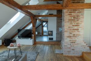 an attic living room with wooden beams and a brick wall at Penzion Nový Rybník in Obořiště