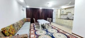 a living room with a table and a couch at Яншина 6 in Qyzylorda