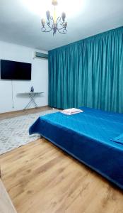 a large blue bed in a room with a television at Яншина 6 in Qyzylorda