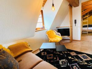 a living room with a couch and a chair at Ferienwohnungen Im Eugenhaus in Rosenfeld