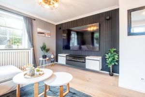 a living room with a large tv on a wall at Haus Breslauer Straße 22a in Süderende