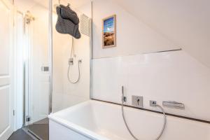 a white bathroom with a shower and a sink at Haus Breslauer Straße 22a in Süderende +30 photos