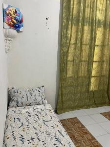 a bedroom with a bed and a green curtain at Residence wafa 1 in Jijel
