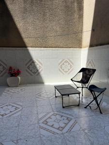 a room with a bench and a table and a chair at Residence wafa 1 in Jijel +2 photos