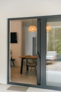 a sliding glass door into a dining room with a table at Wild River 2 in Neporotovo