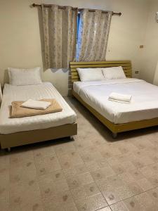 two beds sitting next to each other in a bedroom at Sky&Sea Guesthouse Cha am TK in Cha Am