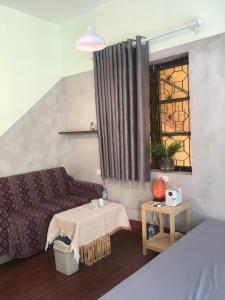 a small bedroom with a bed and a window at Bản làng Home in Thanh Hóa
