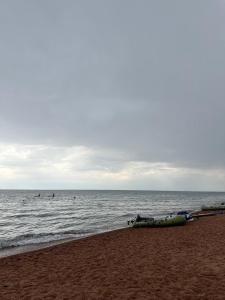 a boat laying on the beach next to the ocean at Ak Bulak in Kurmenty +1 photo