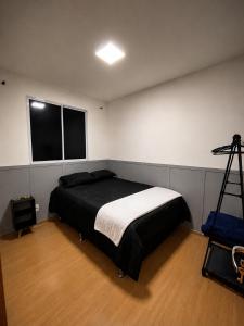 a bedroom with a bed and a tripod in it at Apt Moderno e Confortavel 7 min do Centro em 7L in Sete Lagoas