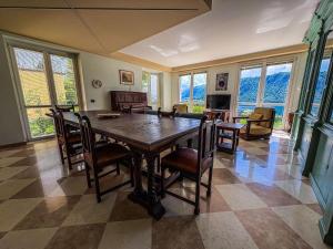 a dining room with a wooden table and chairs at Holiday Home Lake Orta in Pettenasco