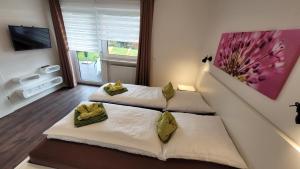 a bedroom with two beds and a tv on the wall at BayVista Lodge - Studios & Apartments in Lam