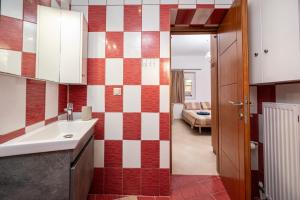 a bathroom with a sink and red and white tiles at Christiana's sweet house in Kos +22 photos
