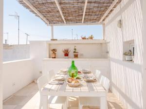 a white table with white chairs and a green bottle at Casa con Vista a POLIGNANO a Mare in Polignano a Mare +14 photos