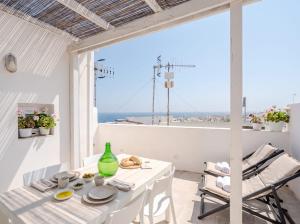 a white dining room with a view of the ocean at Casa con Vista a POLIGNANO a Mare in Polignano a Mare