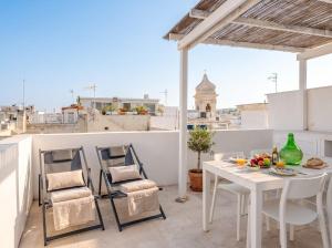 a white table and chairs on a balcony with a view at Casa con Vista a POLIGNANO a Mare in Polignano a Mare