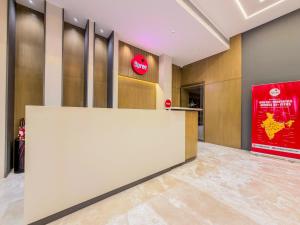 a lobby with a large white counter and a red sign at Jain Tree by Spree Hotels Vellore in Vellore