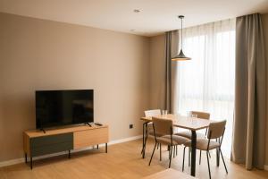 a dining room with a table and a flat screen tv at TeneaHome - Escuelas Pías in Yecla