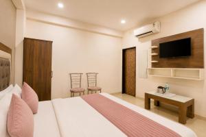 a hotel room with a bed and a tv at Hotel Gold Ston Near Yashoda Hospital & Vaishali Metro in Ghaziabad