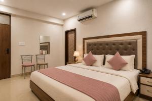 a bedroom with a large bed with pink pillows at Hotel Gold Ston Near Yashoda Hospital & Vaishali Metro in Ghaziabad