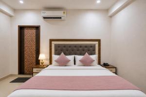 a bedroom with a large bed with pink pillows at Hotel Gold Ston Near Yashoda Hospital & Vaishali Metro in Ghaziabad +14 photos