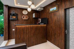 a lobby with a wooden wall with a bar and a clock at Hotel Gold Ston Near Yashoda Hospital & Vaishali Metro in Ghaziabad
