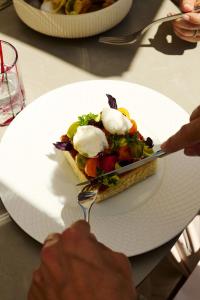 a person is holding a plate with a dessert on it at Alpiana Dolce Vita Mountain Resort & SPA in Vollan