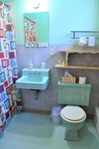 a bathroom with a green toilet and a sink at Royal Motel in Ironwood