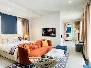 a bedroom with a bed and a couch at Romlaphass Boutique Villa in Kalasin