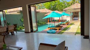 a view of a patio with a pool and an umbrella at Eden Collection Thalpe in Talpe
