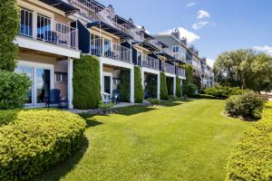 a row of apartment buildings with bushes and grass at 111 Water Street Inn in Boyne City