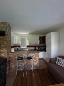 a kitchen with a counter and two bar stools at Villa Pjene in Konjic