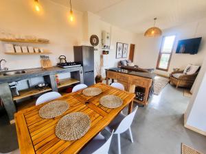 a kitchen and living room with a wooden table and chairs at Oudam Cottage in Carnarvon +8 photos